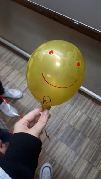 Balão amarelo com olhos e sorriso desenhados